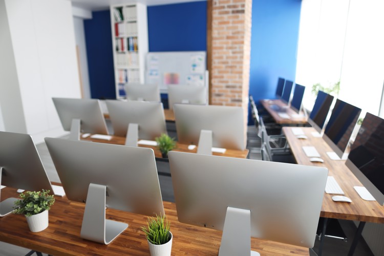 Åbent kontor med mange skærme og arbejdspladser